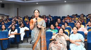 Dr. Vineeta Goel addressing Delhi University students and faculty during a breast and cervical cancer awareness workshop, featuring a TFD (Touch, Feel & Detect) session on breast self-examination.