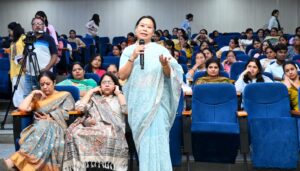 Dr. Vineeta Goel addressing Delhi University students and faculty during a breast and cervical cancer awareness workshop, featuring a TFD (Touch, Feel & Detect) session on breast self-examination.